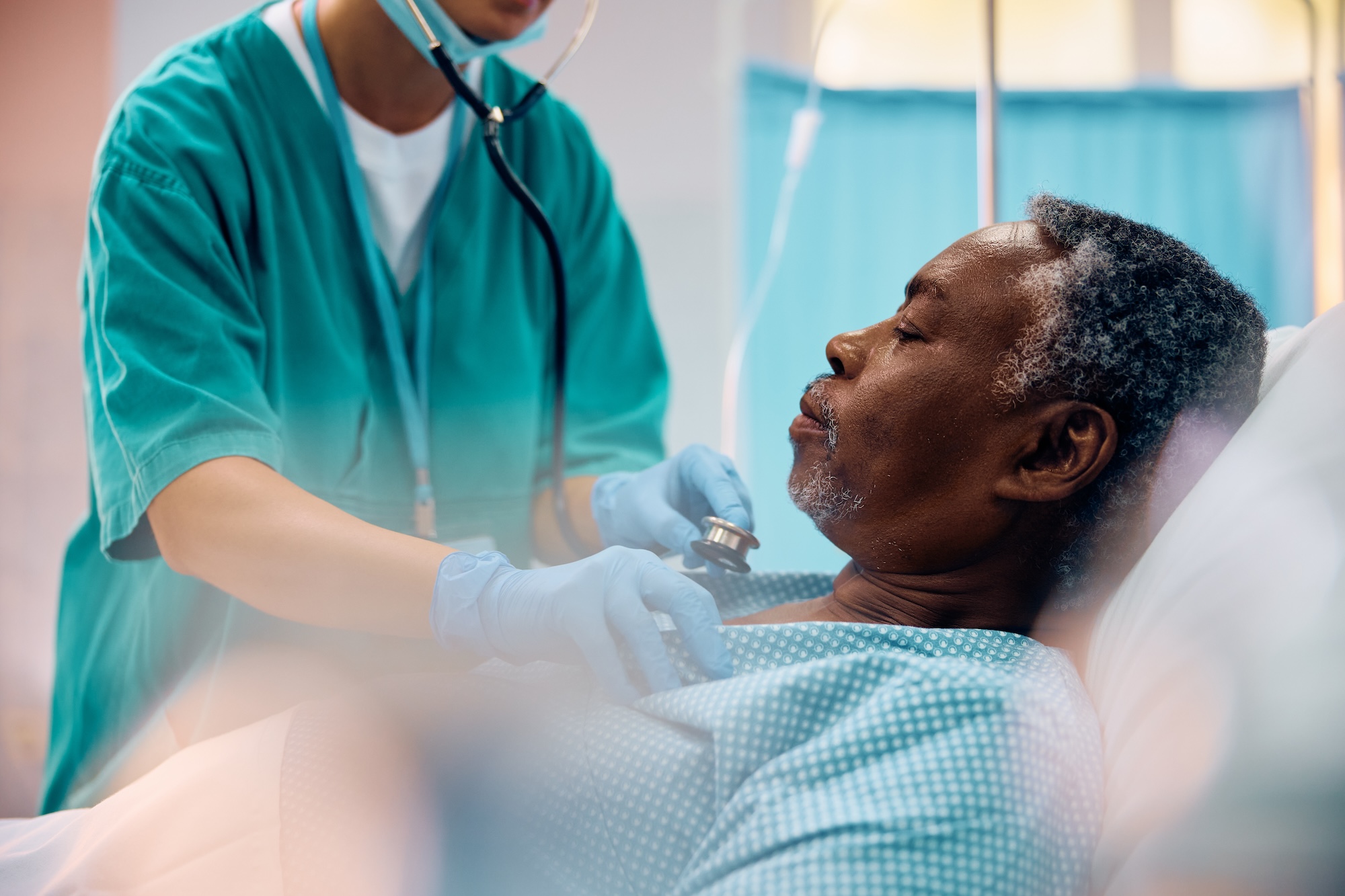 Nurse checking heartbeat of senior black patient.